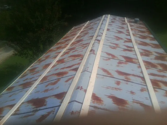 Rusted metal roof panels with new wood purlins before replacement — Storm Damage Roof Repair in Scott by Roofing Brothers