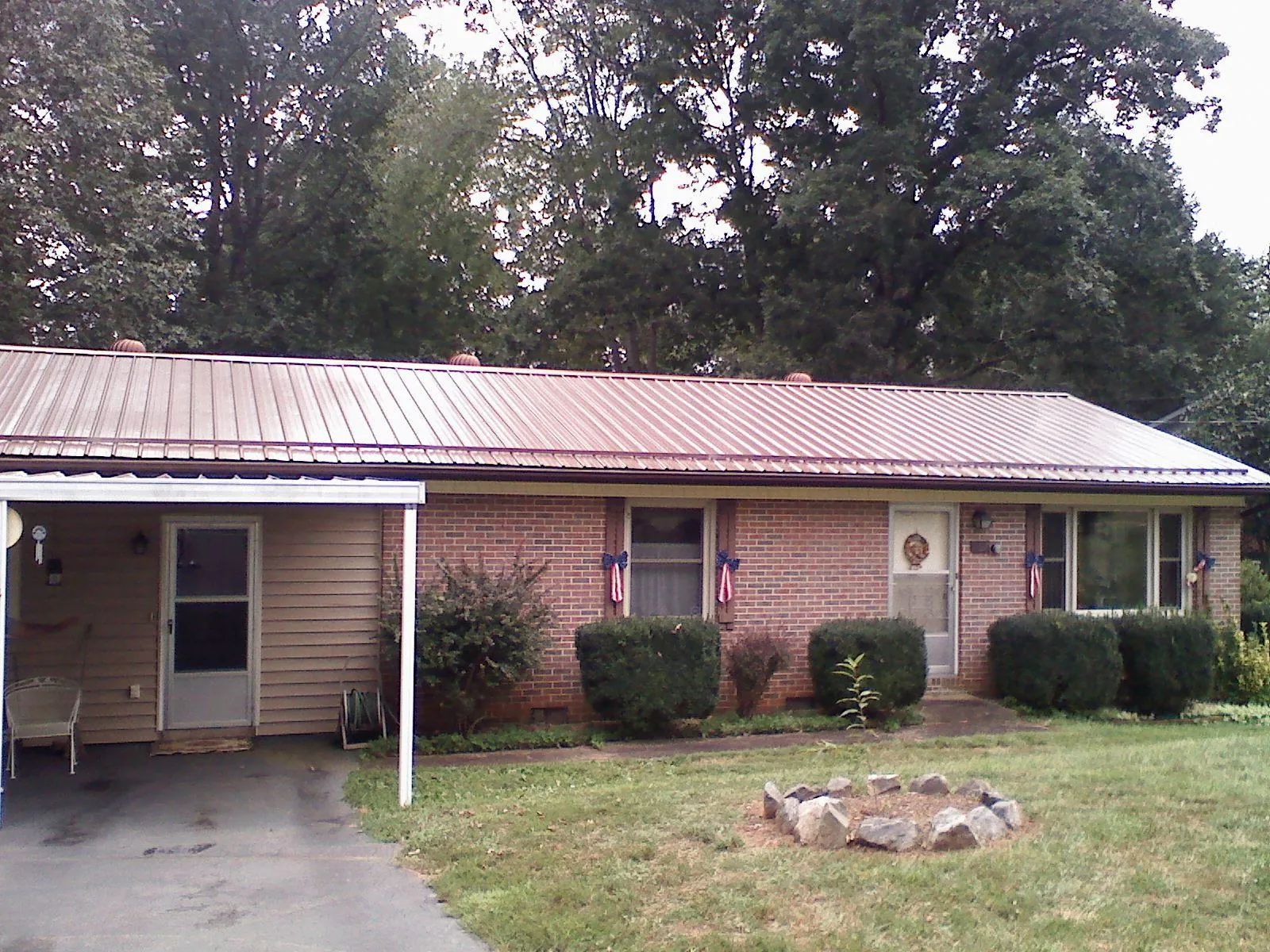Bronze metal roof and carport on a brick ranch home — Roof Repair work by our crew in Scott